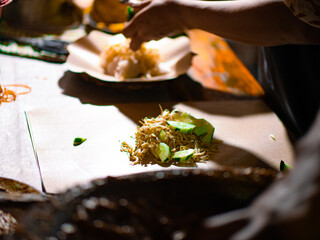 Indonesian street vendor preparing tahu tek. Tahu tek is one of the typical dishes of the city of Lamongan. consists of half-cooked fried tofu and lontong cut into small pieces with scissors.