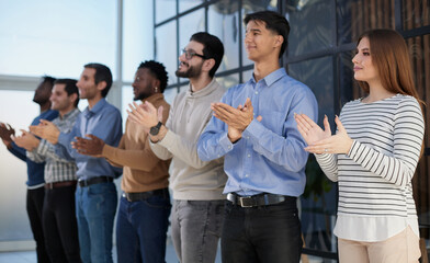 Obraz premium Smiling multiethnic colleagues celebrating common business success or victory in the office.