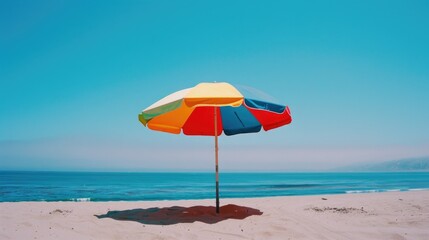 A bright and cheerful umbrella sits atop a sunny beach, perfect for a day out or as a decorative accent
