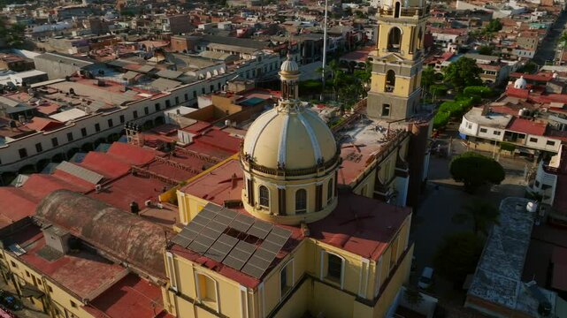 Stunning orbit drone flight overlooking the yellow catholic church Our Lady of the Sanctuary in Tamazula, Mexico. Right to left orbit