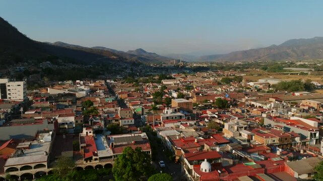 Tamazula cityscape and the Lady of the Sanctuary catholic church. Dolly out backward drone flight