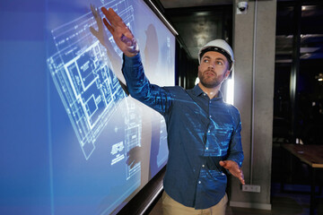 Modern exterior. Man architect in hard hat is near projector with construction plan