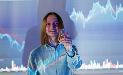 Positive female is with digital currency coin. Businesswoman is against projector with graphs,...