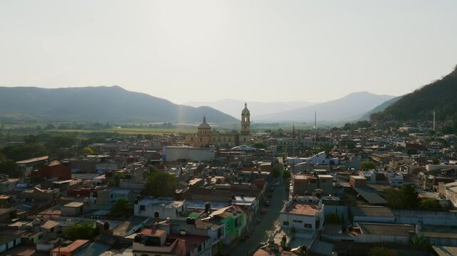 Fast flight overlooking the Tamazula de Gordiano city center and the Lady of the Sanctuary church. Dolly in drone aerial