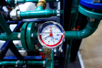A pressure gauge with a scale for measuring the pressure of a liquid or gas in a confined space located at a pipe connection.