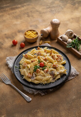 Medium shot of two bowls (black and green) of fresh pasta noodles with meat and tomato ragu with forks, parsley, red wine and grated cheese