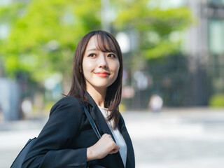 爽やかに街を歩く女性ビジネスパーソン
