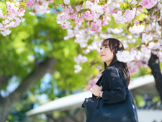 スーツを着た若い女性と桜のポートレート