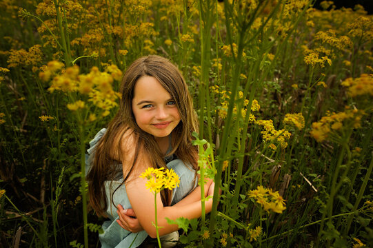 Close up portrait beautiful young girl sitting yellow flower field
