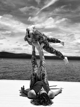 Acroyoga duo flying above a lake