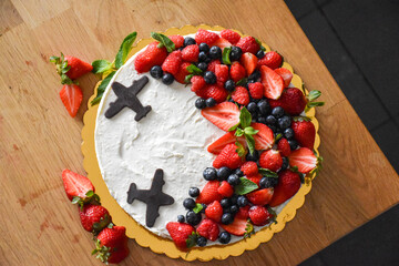 Fruit cake with cream and chocolate planes