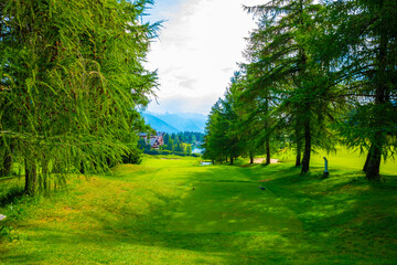 Golf Course with Mountain View and Clouds in a Sunny Summer Day in Crans Montana, Valais, Switzerland.