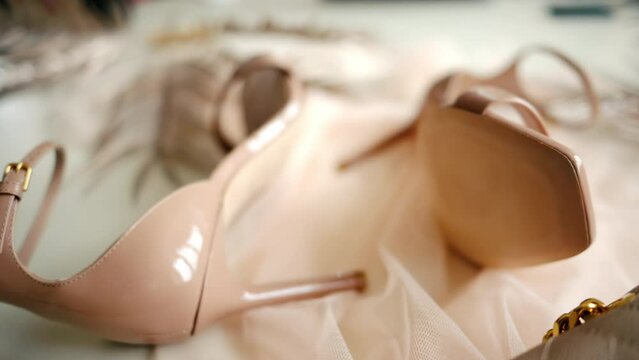 A beige pair of strappy heels on a piece of tulle