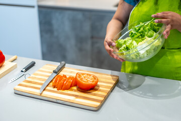 Cutting tomatoes and preparing salad at home while recording
