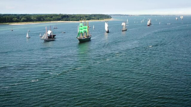 Tall ships passing Kieler F&ouml;rde to Kiel week.Parade of sailing ships during Kiel Week, Kiel Fjord,Schleswig-Holstein, Germany. Reverse shot, moving backward to reveal entire procession of ships.