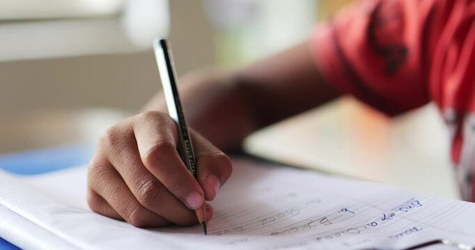 Boy learning to write on his notebook
