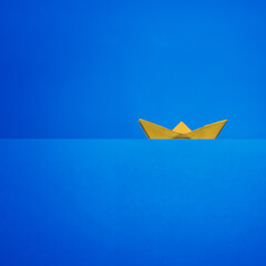 minimalistic paper boat on blue background