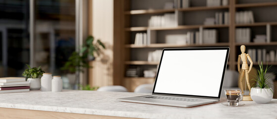 A laptop computer mockup on a table in a contemporary spacious living room or private office. © bongkarn