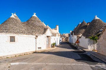 Famous traditional old dry stone trulli houses with conical roofs in Alberobello, Italy.