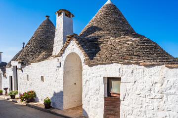 Famous traditional old dry stone trulli houses with conical roofs in Alberobello, Italy.