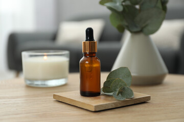 Aromatherapy. Bottle of essential oil and eucalyptus leaves on wooden table