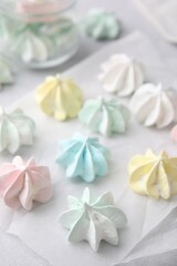 Tasty meringue cookies on light grey table, closeup