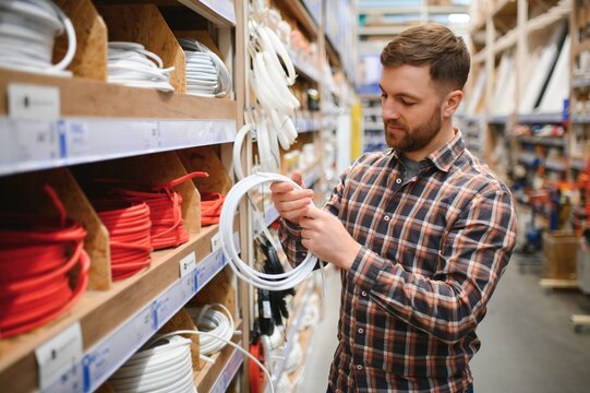 Worker selects an electrical cable at a hardware store