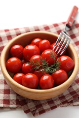 Tasty pickled tomatoes in bowl, dill and fork on white table