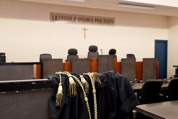 A lawyer's toga close-up in an empty Italian courtroom with the inscription in Italian 'The law is...