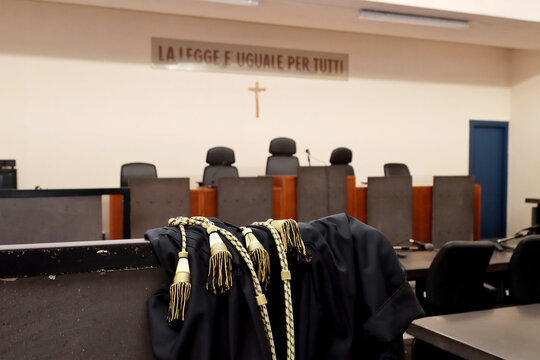 A lawyer's toga close-up in an empty Italian courtroom with the inscription in Italian 'The law is the same for everyone'. No people