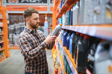 seller man with canister of motor oil in auto store