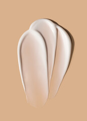 creamy smear of white cosmetic texture close up on beige background skin care concept