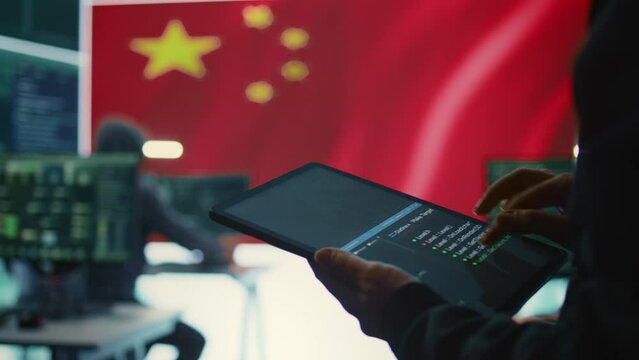 Chinese hacker uses a tablet in governmental cyber operations office to work on hybrid warfare and political manipulation. Inflicting manipulation and propaganda for the communism ideology. Camera B.