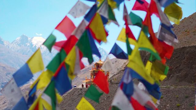 Closeup shot of Gue Monastery with defocused prayer flags waving in front of it as seen on the way towards Spiti Valley in Himachal Pradesh, India. Selective focus on the Gompa behind the prayer flags