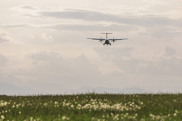 Passenger airplane on the departure, flying on the blue skyscape at sunset. Travel, transportation, and vacation concepts.
