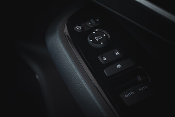 Close up of modern car door control panel button with lock button and automatic window adjustment in dark black tone. Interior decoration of modern cars in 2024.