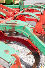 detail of a plow painted in rusty red and green, agricultural machinery