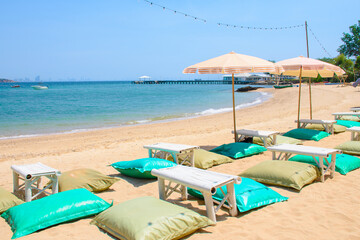 Beautiful tropical beach with beanbag chairs with bamboo tables and umbrellas is a place  relaxing and beach activities at koh larn island. View of tropical seascape on vacation holiday beach.
