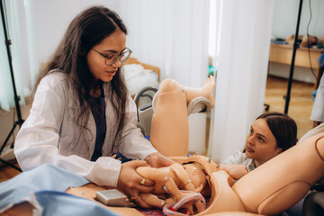 students learn to deliver a baby on a mannequin