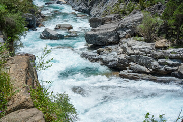 blue-white water cascading over rocks, waterfall in a Spanish Pyrenees mountain river