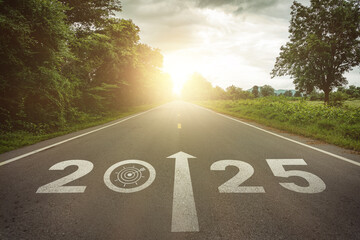Goals, targets in New year 2025 or straightforward concept. Text 2025 and dartboard with dart icon on the road in the middle of asphalt road at sunset. Life, business planning, challenge, strategies.