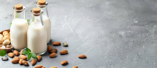 Vegan alternative nut milk in glass bottles on a gray background. Healthy vegan food concept. Copy space image. Place for adding text or design