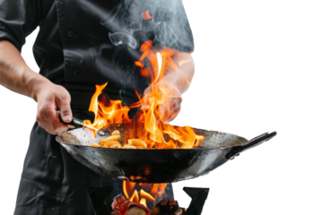 Chef in white uniform stir-frying vegetables in wok with high flames, isolated on white background. Close-up of man cooking in wok with flambe technique