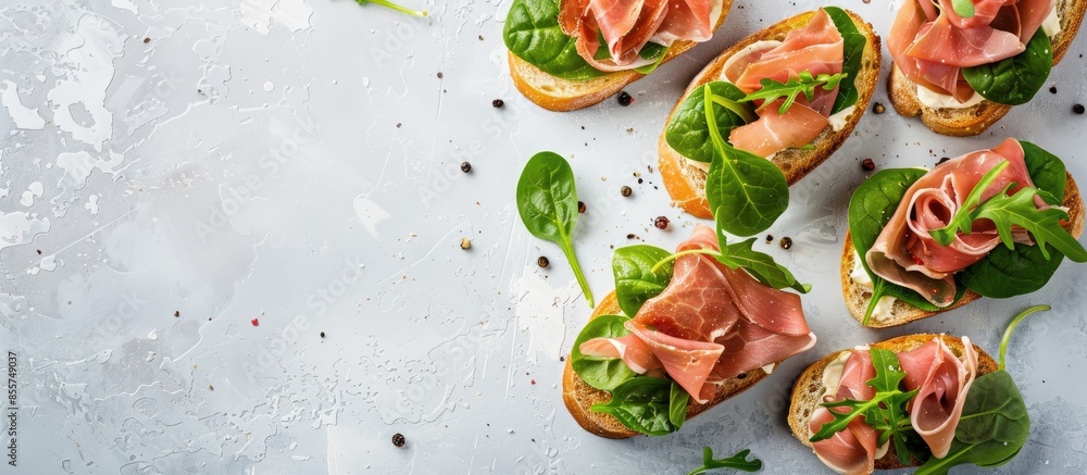 Fototapete tasty ham, jamon bruschettas with lettuce and spinach on pastel background. with copy space image. p