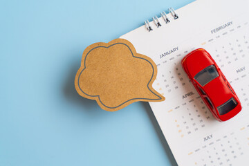 For monthly expenses, budget, financial insurance concepts. Real brown paper cut of  speech bubble, for adding message on white calendar and car model  with blue background