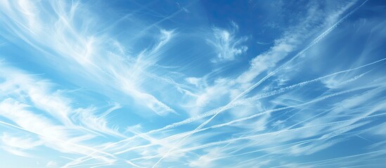 Obraz premium Clear blue sky with cirrus clouds and plane tracks. Abstract natural pattern, texture, close-up. Concept art, meteorology, ecology, climate change, religion, heaven, graphic resources