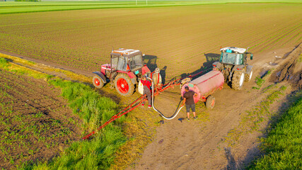 Aerial view on tractor with sprayer came for reload, water, herbicide and pesticide