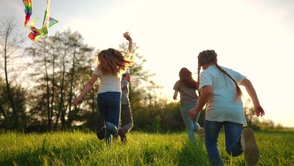 happy family. big family running with a kite. people in the park children child running together in the park at sunset silhouette. mom fun dad daughter and son are running. concept dream. kids run