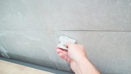 Grouting ceramic tiles using a fugue. Worker putting fugue on tiles closeup