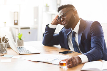 Things getting worse. Young african american businessman drinking from stress, holding glass of...